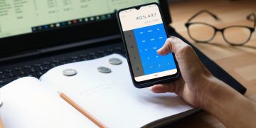 Como utilizar aplicativos de controle financeiro para organizar suas finanças Closeup shot of an entrepreneur working from home on his personal finances and savings